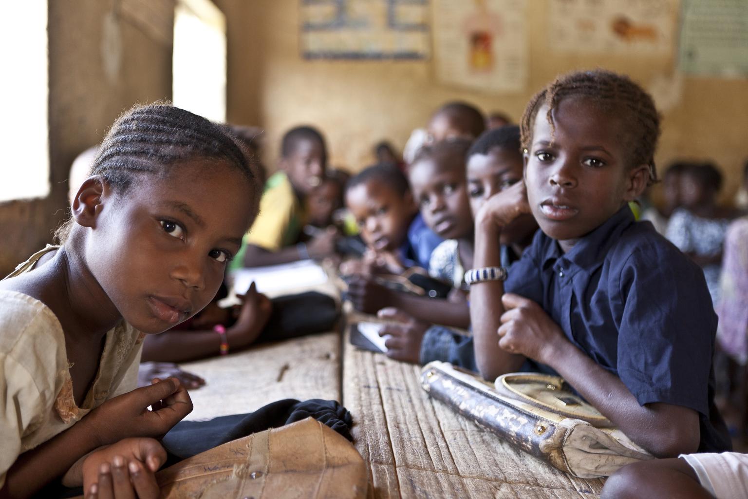 'Bahadou 2 school in Timbuctu. Hamssatou Touré (10), pictured in the front, and the other children are third-year students. The Bahadou 2 school is one of the 25 traditional schools located in the city of Timbuktu. With 1,080 students distributed in two cycles, the school holds large numbers of children in classrooms. After the departure of rebels who were driven out by the Malian and French armies, and in response to the humanitarian crisis, UNICEF provided schools with education and recreational kits for children and teaching kits teachers. Another partner, WFP has established a school canteen to keep children in school and address absenteeism from classes. The Timbuctu region is situated about 1050 km from the capital Bamako and is the 6th and largest region of Mali.